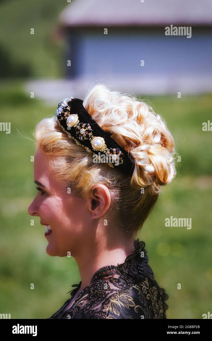 Portrait of blonde woman in lace dress with headband and curly hair , side shot Stock Photo
