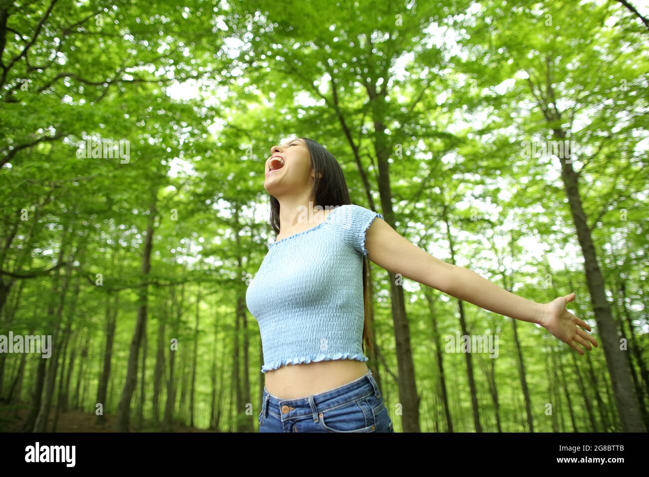 Asian excited woman celebrating vacation stretching arms and screaming ...
