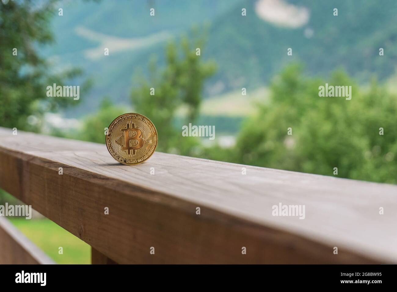 Bitcoin golden crypto coin on wooden terrace with natural mountain and  green trees background with copy space. Cryptocurrency mining and  environment i Stock Photo - Alamy