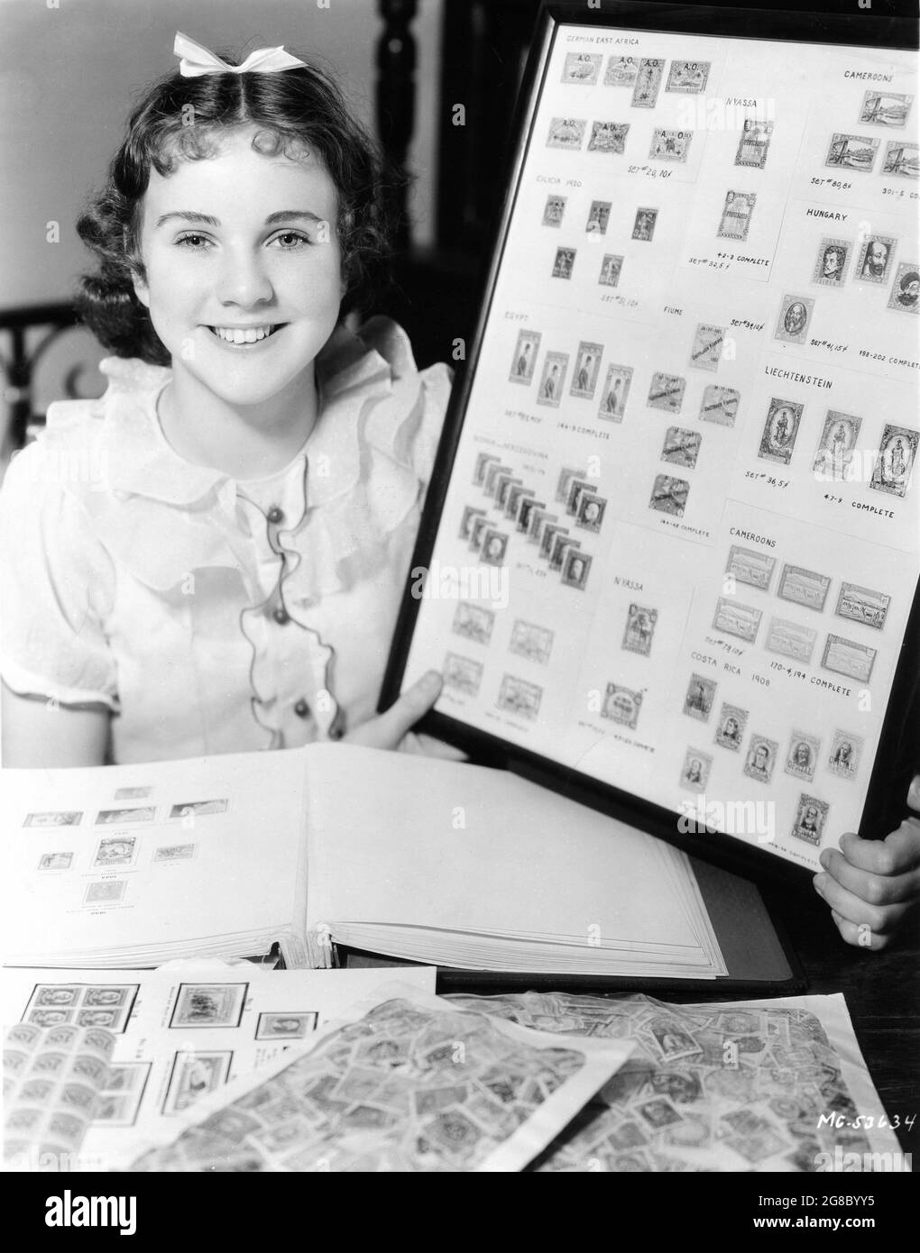 DEANNA DURBIN 1936 candid portrait with her Stamp Collection publicity during her short-lived contract with Metro Goldwyn Mayer Stock Photo