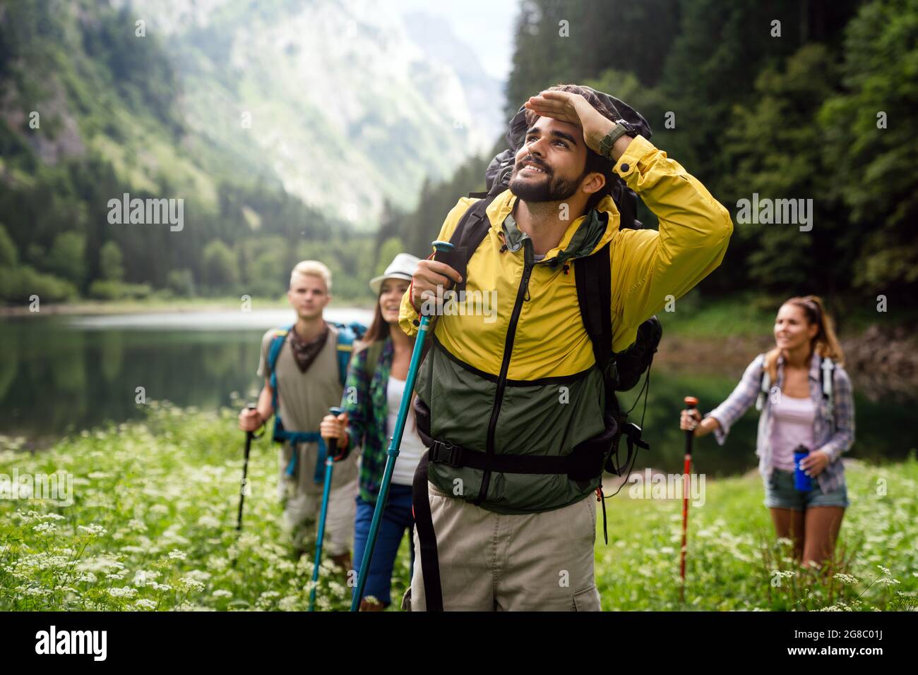 Group of young friends hiking in countryside. Multiracial happy people ...
