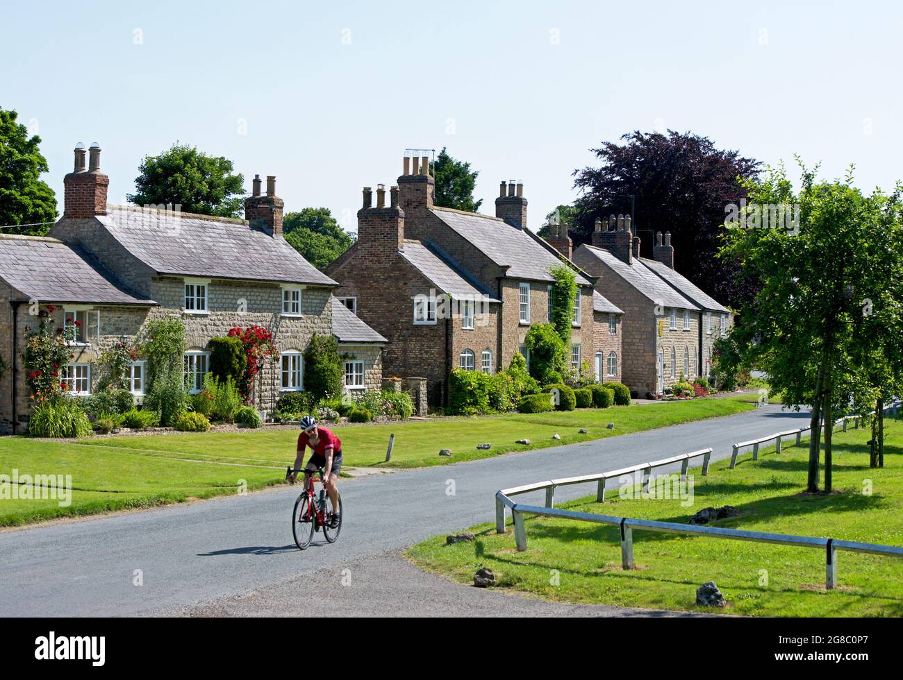 Man cycling in the village of Langton, near Malton, North Yorkshire