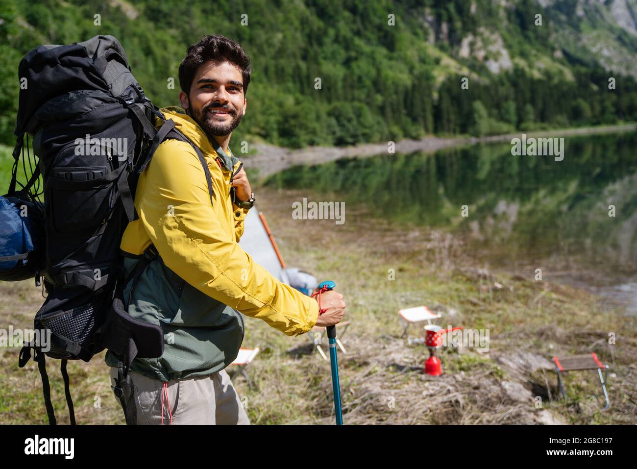 Handsome happy backpacker man hiking, camping through mountain forest ...