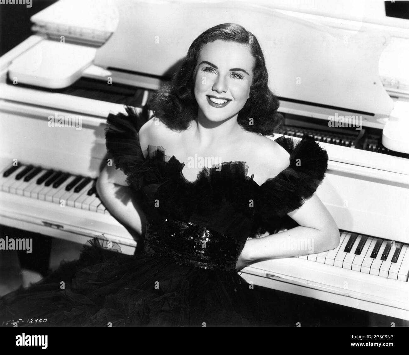 DEANNA DURBIN Publicity Portrait leaning on Piano in I'LL BE YOURS 1947 director WILLIAM A. SEITER from the screenplay The Good Fairy by Preston Sturges adapted by Felix Jackson associate producer Howard Christie producer Felix Jackson Universal-International Pictures Stock Photo
