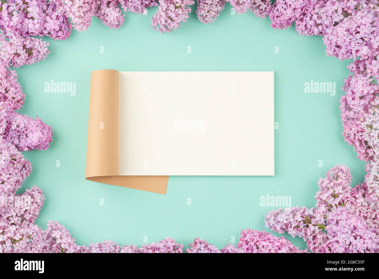 Open notepad with lilac flowers Stock Photo