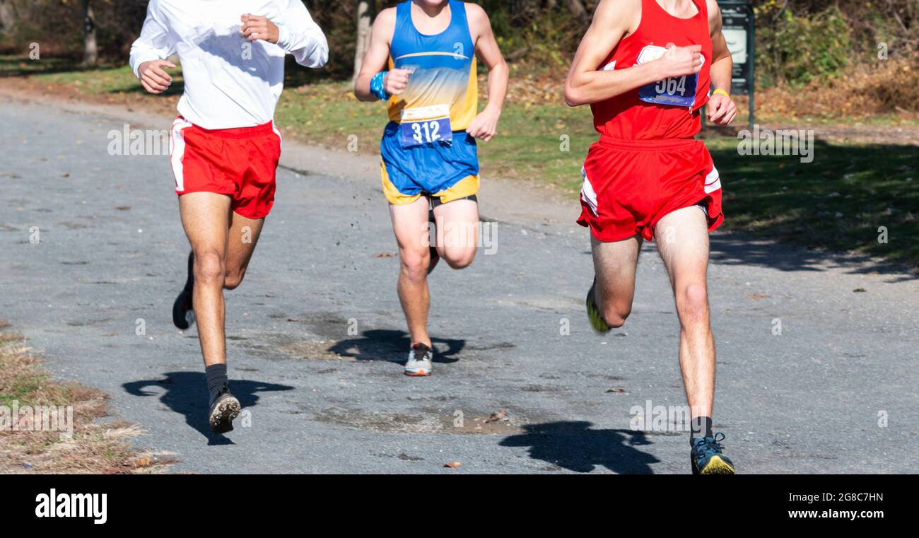 Thre high school boys competing in a cross country running race on a gravel path at Van Cortlandt park in the Bronx. Stock Photo