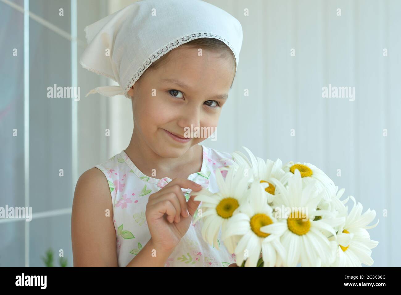 Cute little girl at home with chamomiles Stock Photo - Alamy