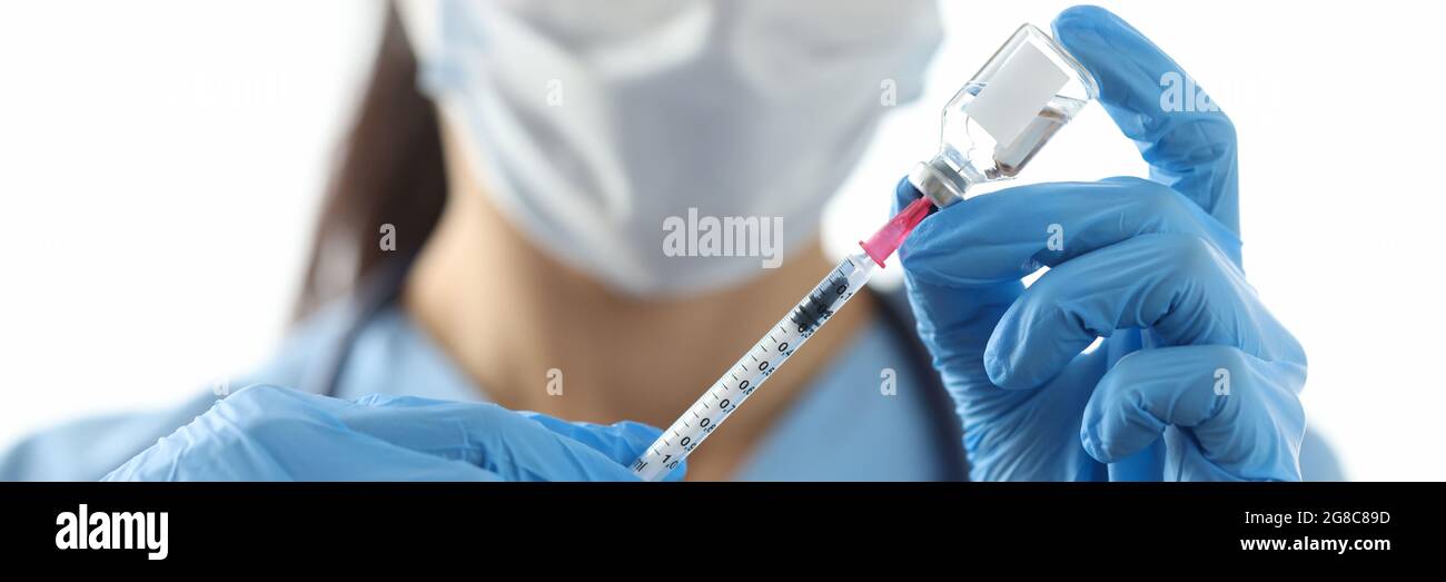 Doctor drawing medicine into syringe from vial closeup Stock Photo Alamy