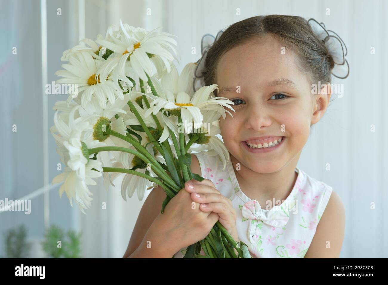 Cute little girl at home with chamomile Stock Photo - Alamy