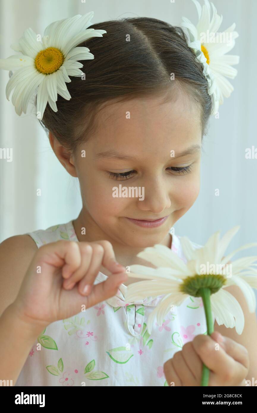 Cute little girl at home with chamomile Stock Photo - Alamy