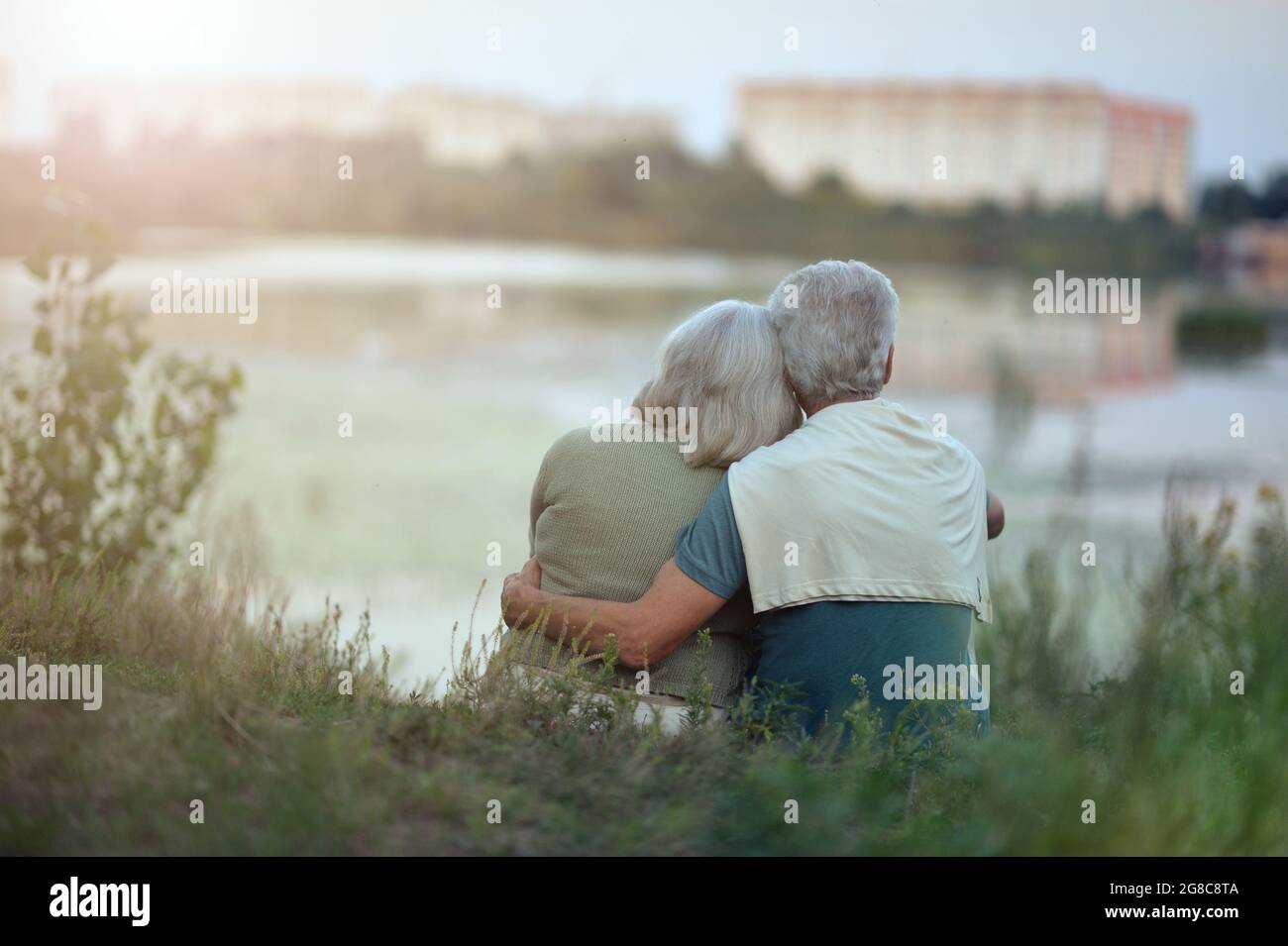Senior couple posing in the park by lake Stock Photo - Alamy