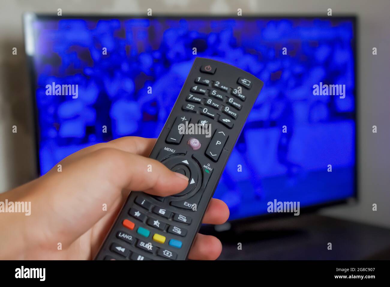 Hand holding tv remote, concept of watching television. Close up hand
