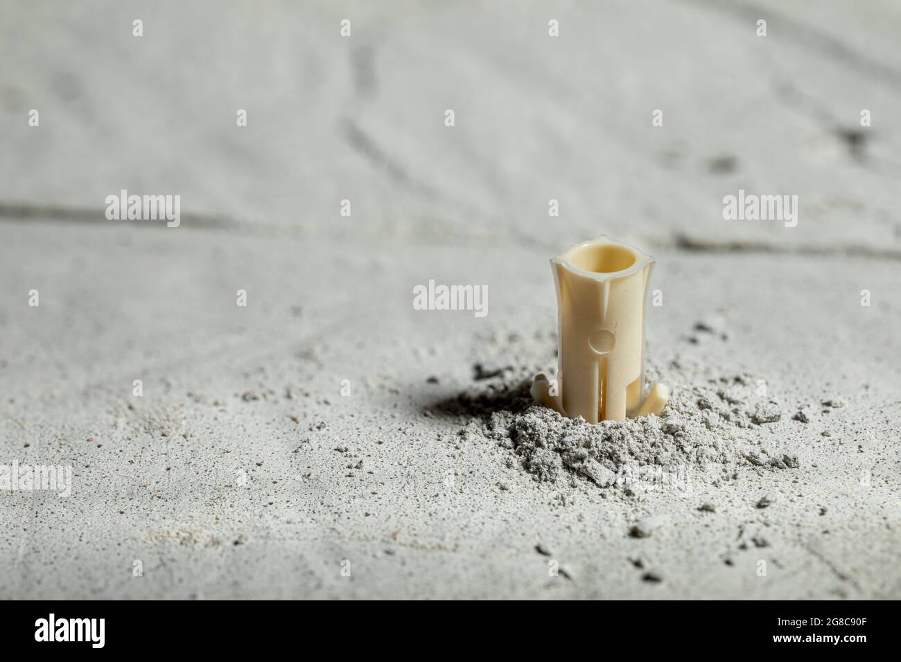 Drilled hole in concrete with screw dowel. Plastic dowel for screws