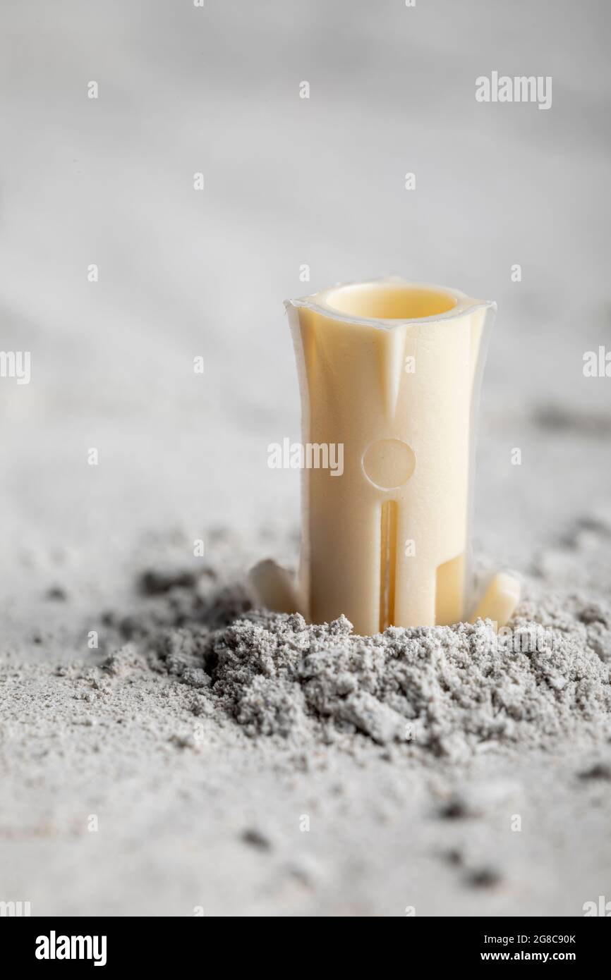 Drilled hole in concrete with screw dowel. Plastic dowel for screws