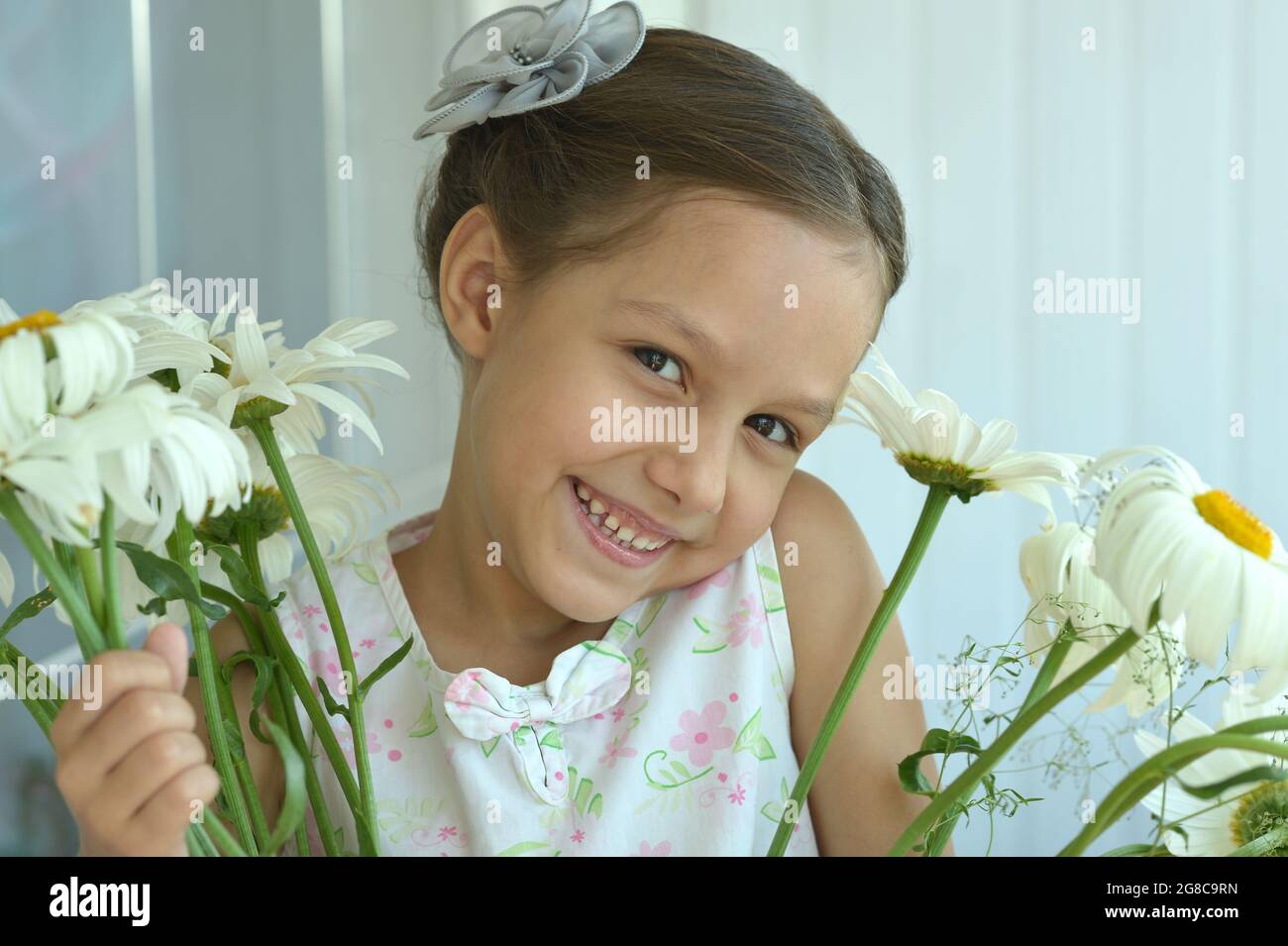 Cute little girl at home with chamomile Stock Photo - Alamy