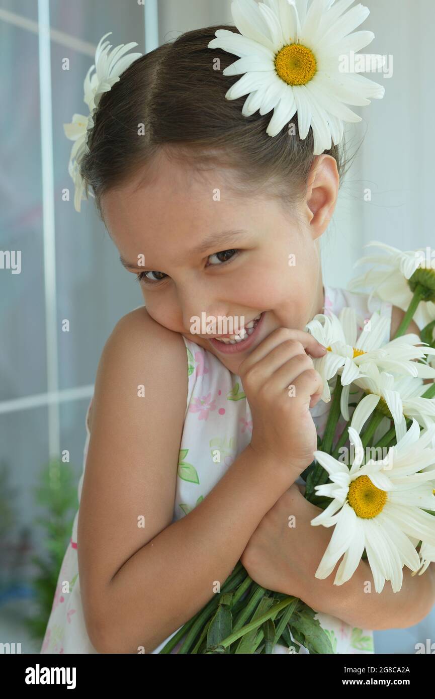 Cute little girl at home with chamomile Stock Photo - Alamy