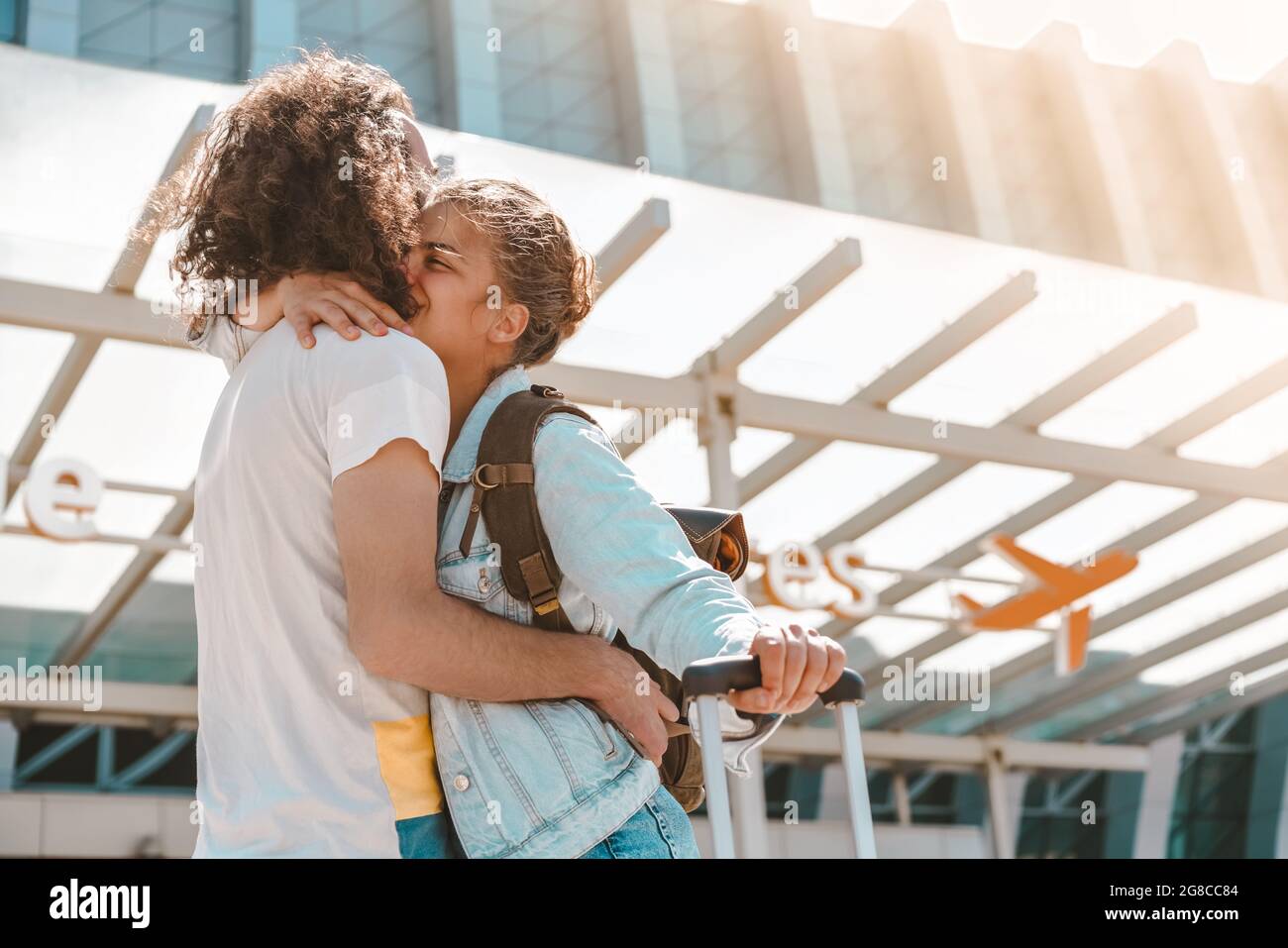 https://c8.alamy.com/comp/2G8CC84/young-international-couple-meeting-at-airport-departures-area-with-luggage-happy-hugging-each-other-saying-good-bye-before-vacation-or-business-trip-2G8CC84.jpg