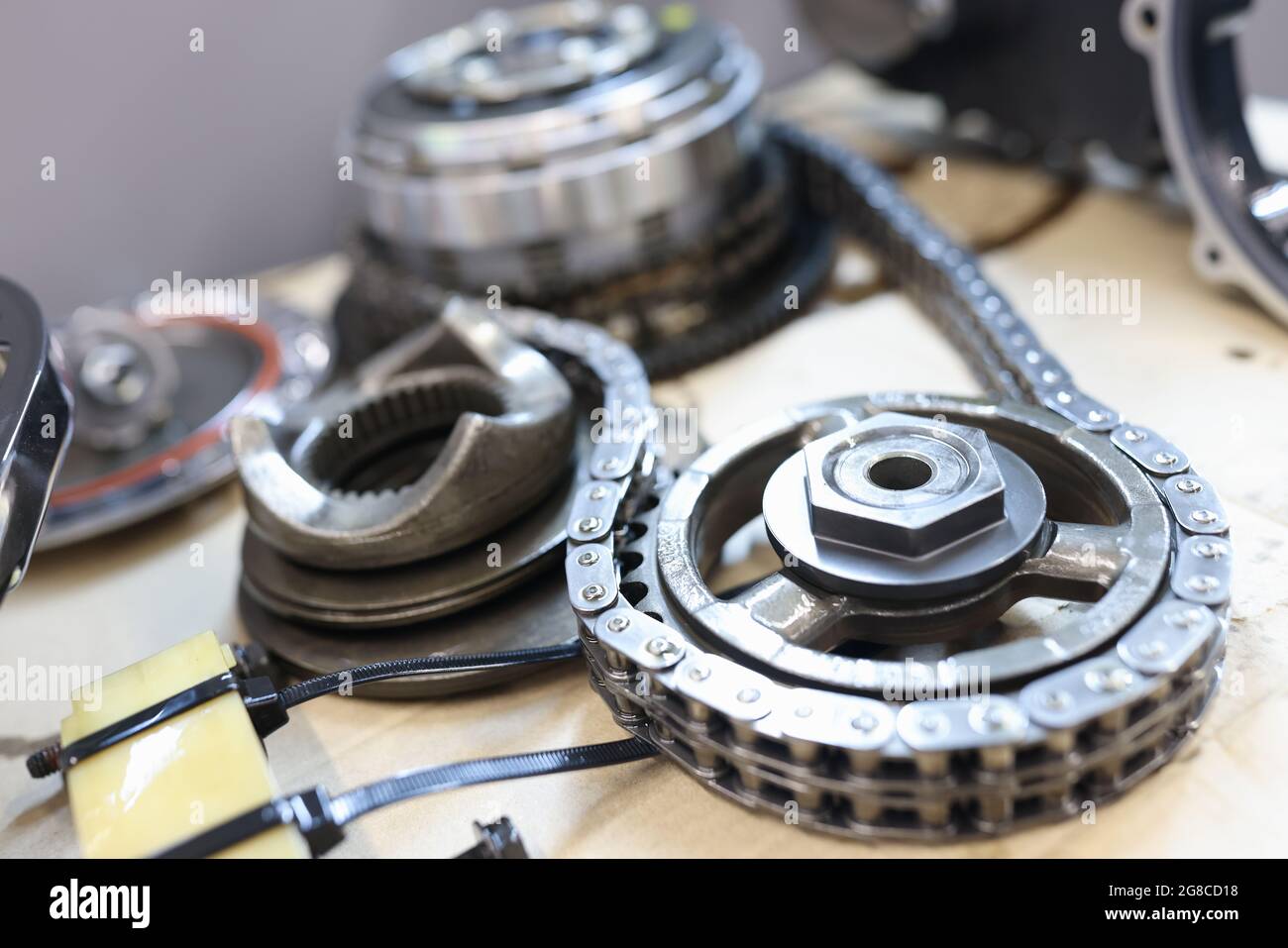 Set of cogwheels connected with steel chain lying at service table Stock Photo