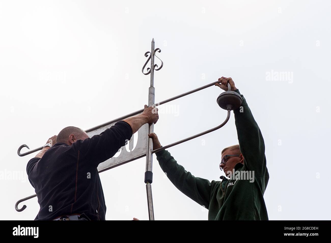 19 July 2021, Saxony-Anhalt, Schönebeck: Craftsmen install a new weather vane on the roof of the Salzland Museum. The building in the Salzelmen district is over 600 years old and the oldest structure in the town. In the past weeks and months, the roof structure had been extensively renovated. The crowning with the weather vane was the completion of this work. Photo: Klaus-Dietmar Gabbert/dpa-Zentralbild/ZB Stock Photo