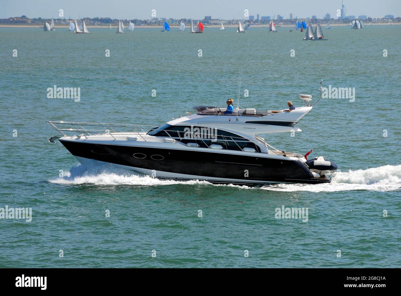 Two-tiered motor cruise on the Solent during Cowes Week with many yachts beyond Stock Photo