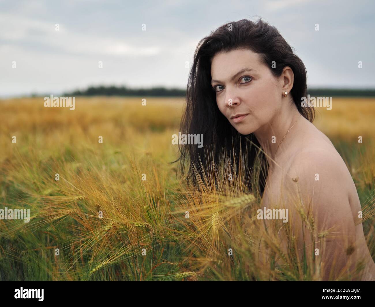 Portrait of young pretty woman without bra in barley field Stock Photo