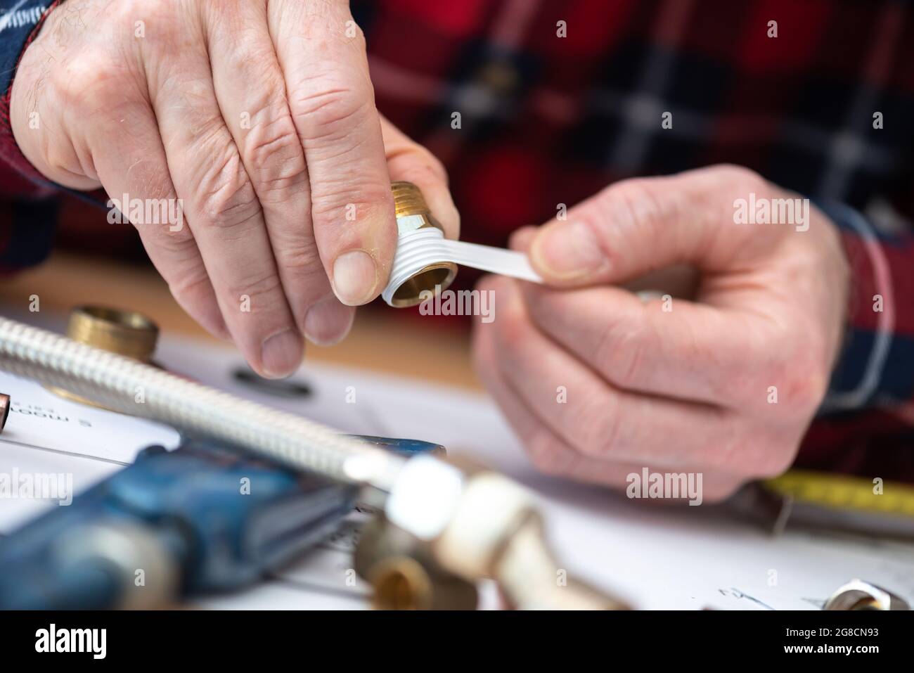 Plumber putting seal tape on a thread of a plumbing fitting Stock Photo Alamy
