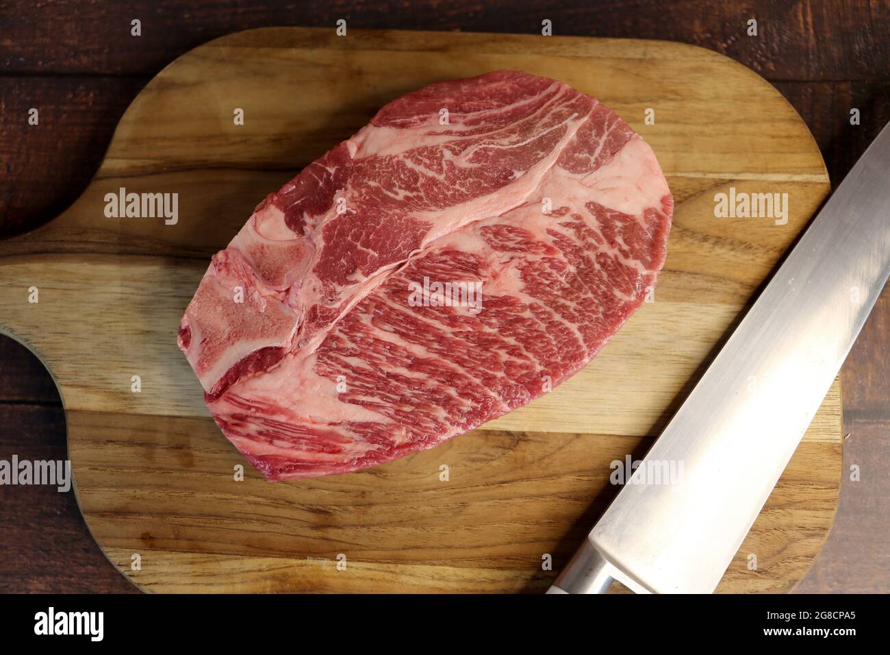 Short Rib or Costela Premium.  Beautiful raw steak under a wooden board on a wooden background. For a brazilian barbecue. Stock Photo