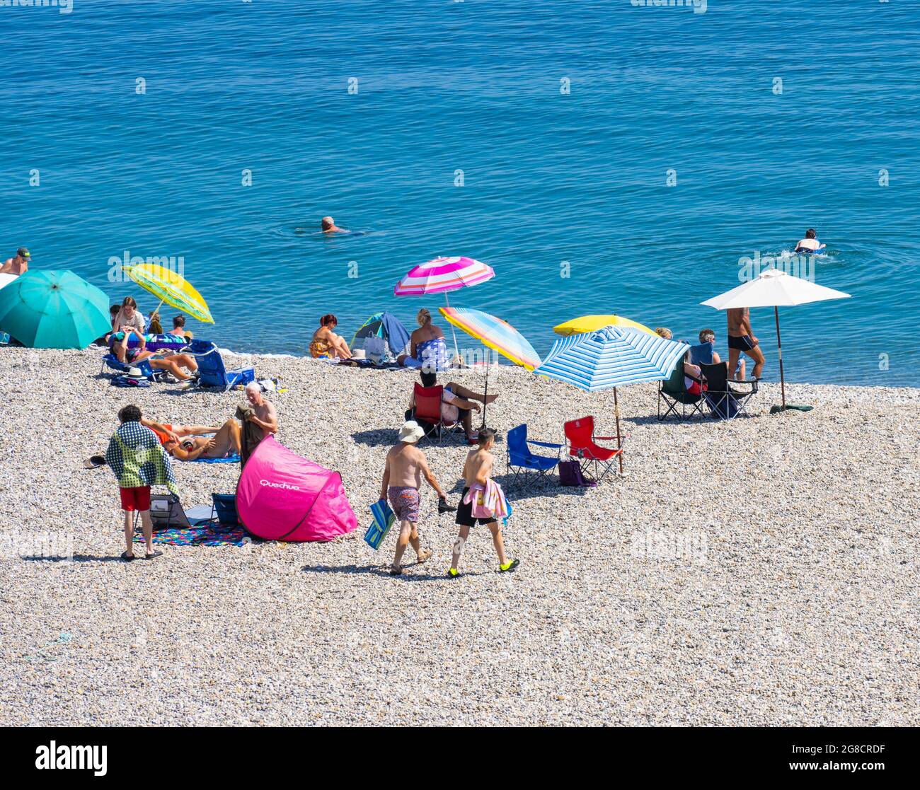 Beer, East Devon; 19th July 2021. UK Weather: Holidaymakers enjoy the glorious sunshine relaxing on the beach and cooling off in the blue sea at the pretty fishing and seaside village of Beer, East Devon. Credit: Celia McMahon/Alamy Live News Stock Photo