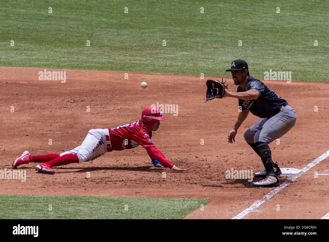 Mexico City, Mexico, July 18, 2021: Carlos Figueroa #12 of the Diablos  Rojos dives into plate of the second base ahead of the tag during the match  between Diablos Rojos and Monclova