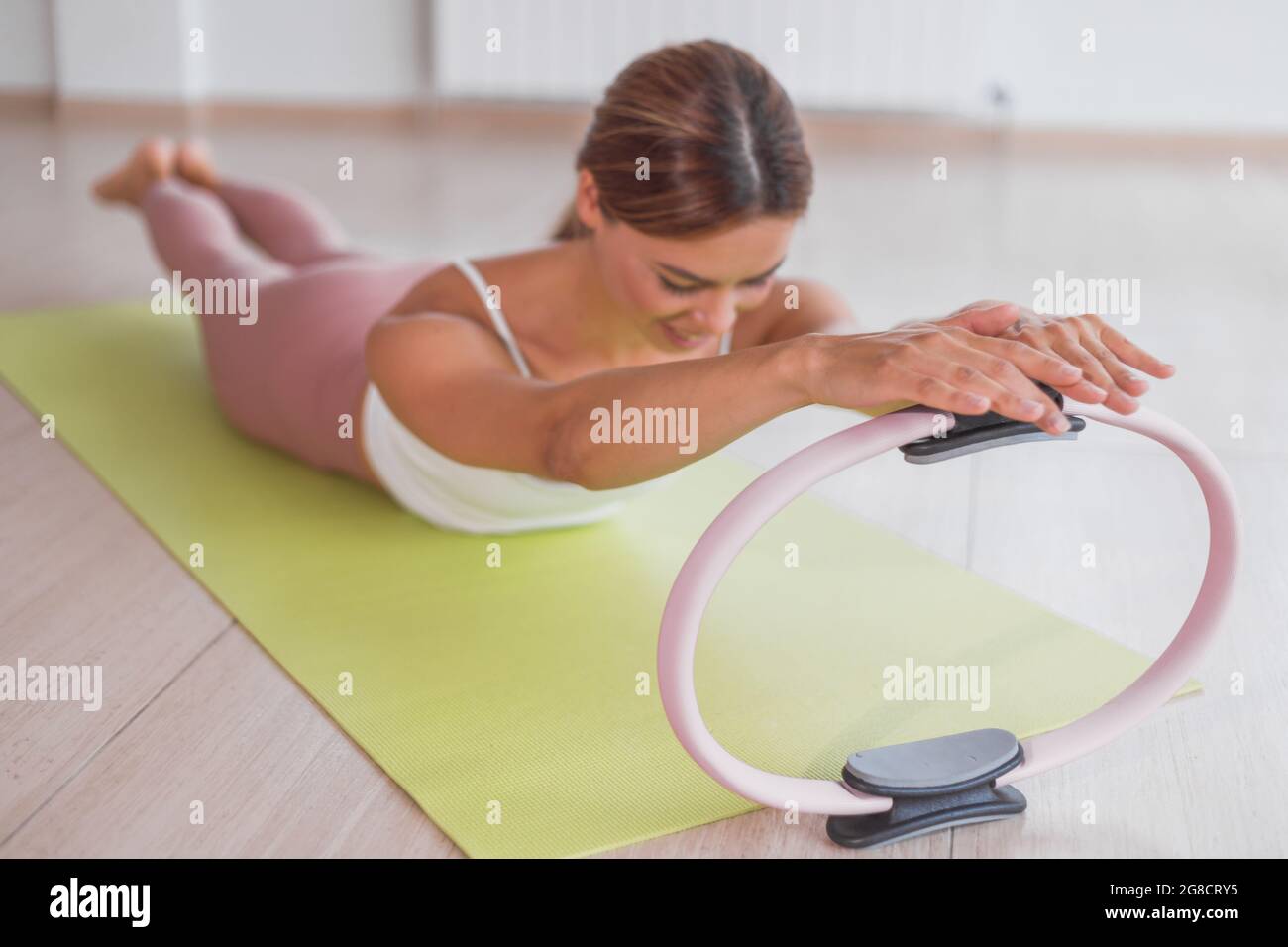 Exercises with pilates ring. Woman doing aerobics workout at sport gym with  panoramic windows Stock Photo - Alamy
