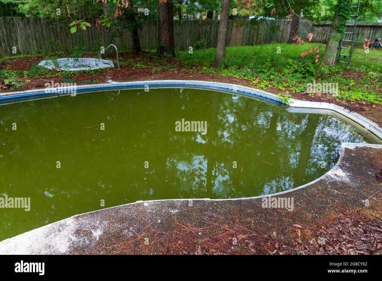 Abandoned and filthy swimming pool in disrepair. Stock Photo