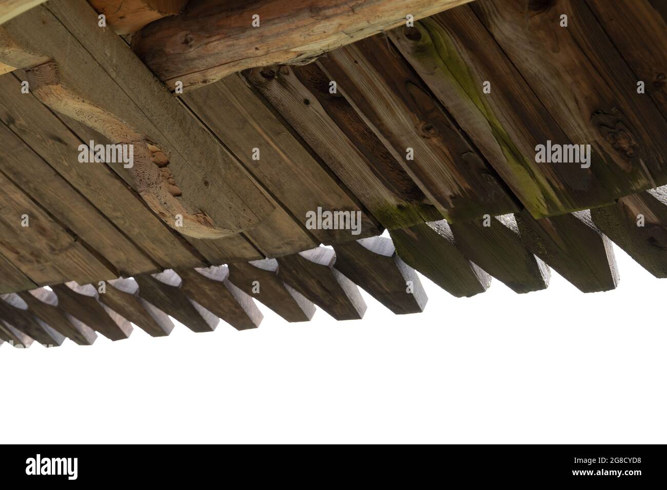 Old wooden house details. Inner side of a roof slope made of planks with decorative carving Stock Photo