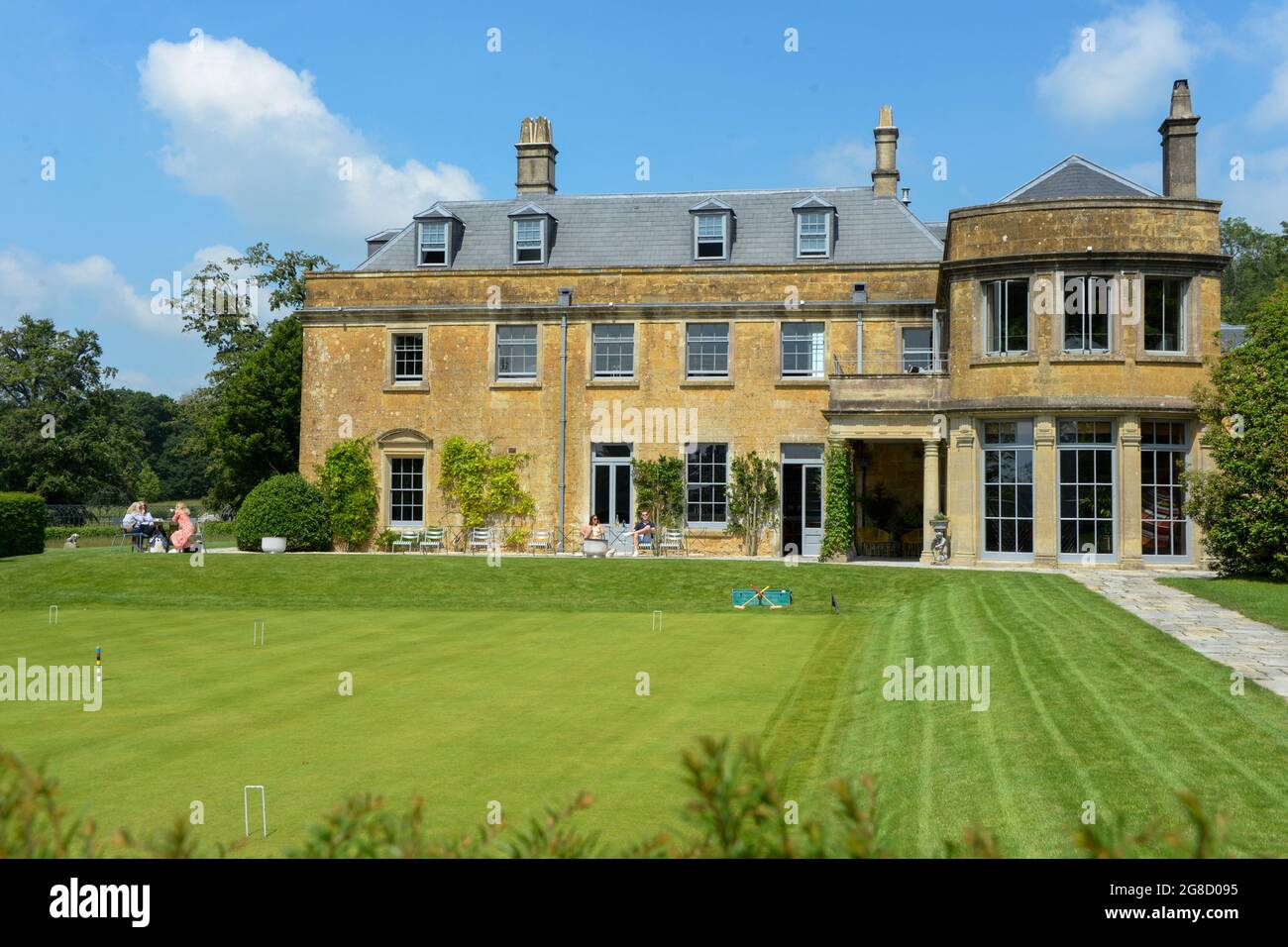 Glamorous people sit on the patio in front of a beautiful