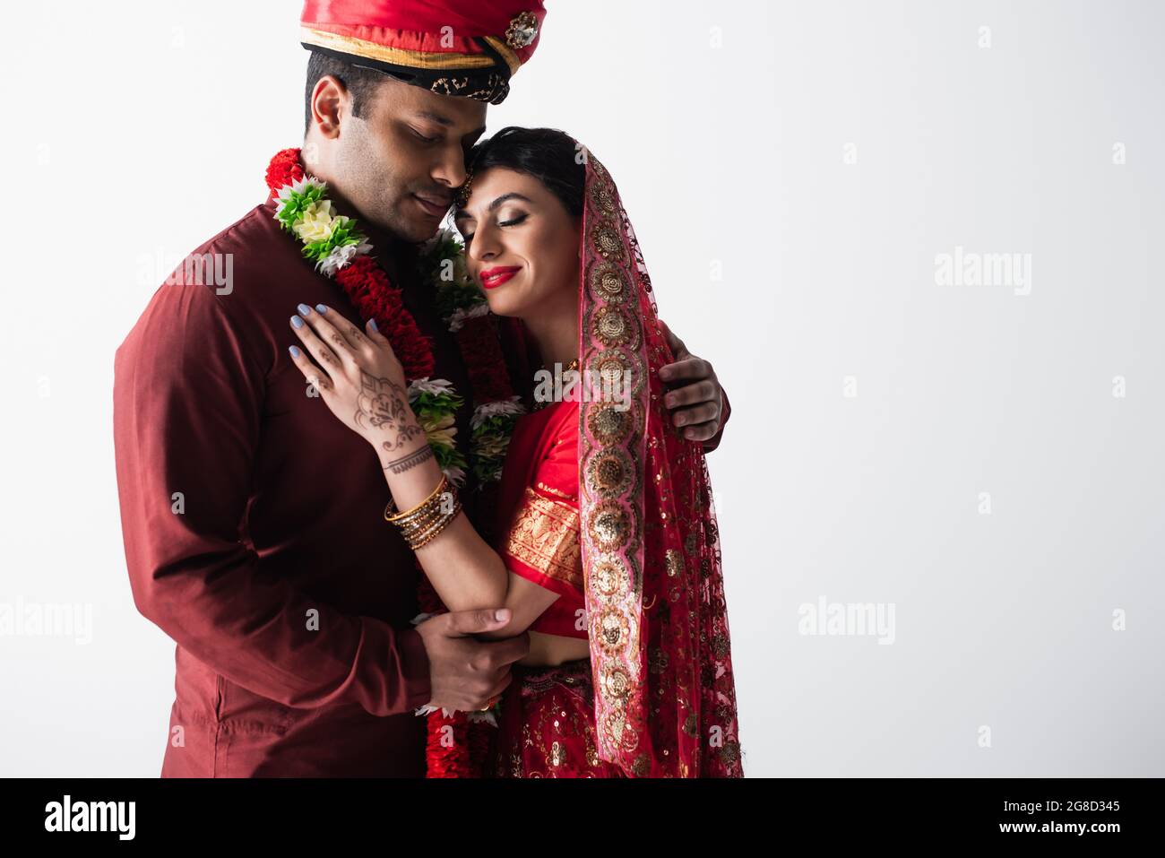 happy indian couple of husband and wife in traditional clothing hugging isolated on grey Stock Photo