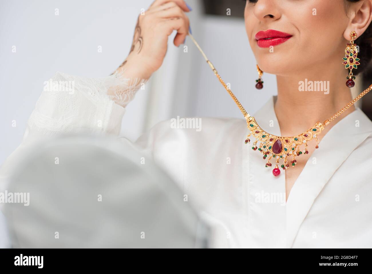 cropped view of young indian bride wearing necklace on white Stock Photo