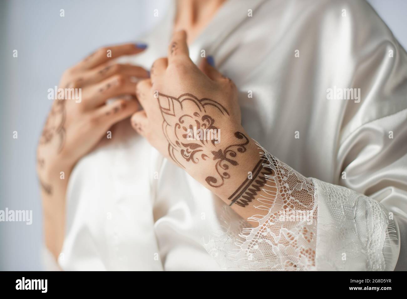 cropped view of young indian woman with mehndi on hands isolated on white Stock Photo