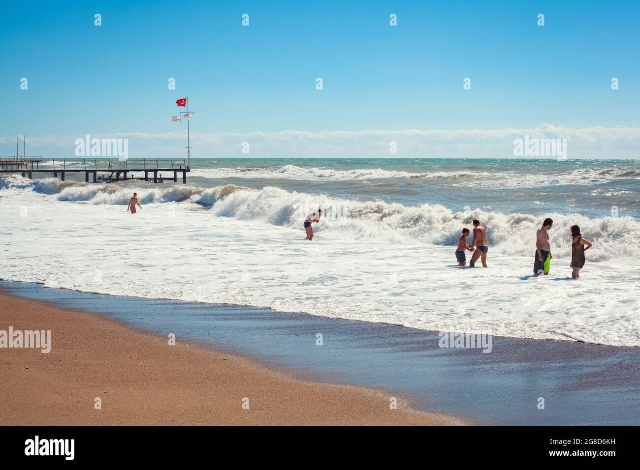 Antalya, TurkeyOctober 18, 2013 Beachgoers playing in the wavy sea