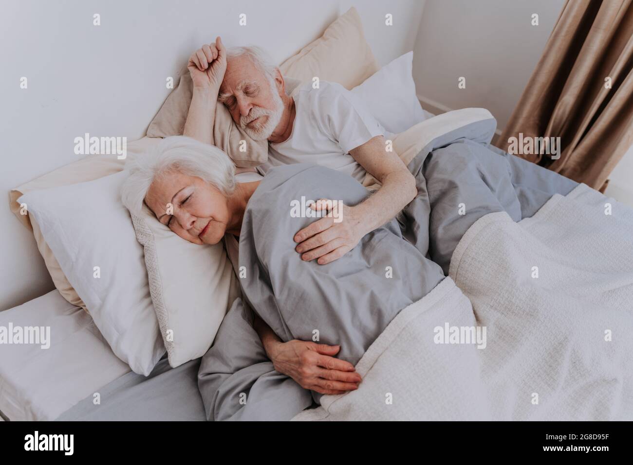 Beautiful senior couple enjoying time together at home - Elderly people sleeping in bed at home Stock Photo