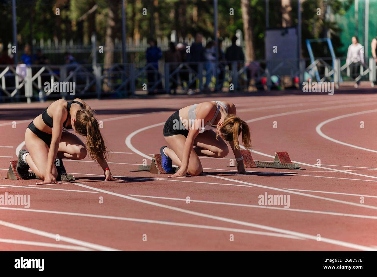 female athletes at starting positions of track and field race Stock Photo Alamy