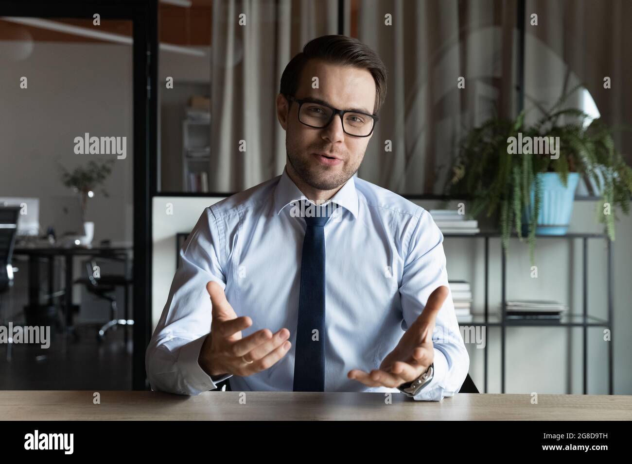 Positive business professional in suit and glasses looking at webcam Stock  Photo - Alamy