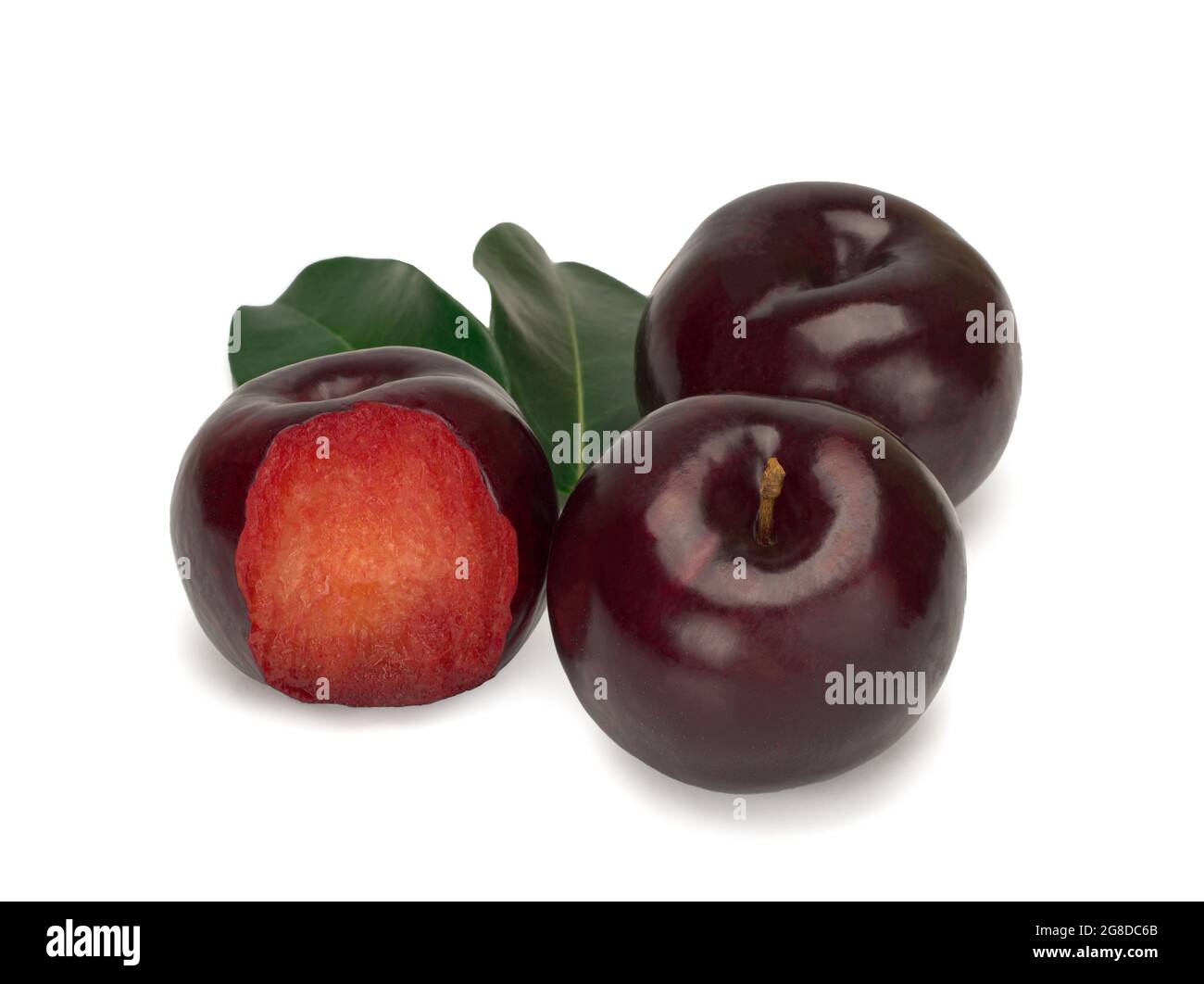 Three plums with leaves on white background Stock Photo