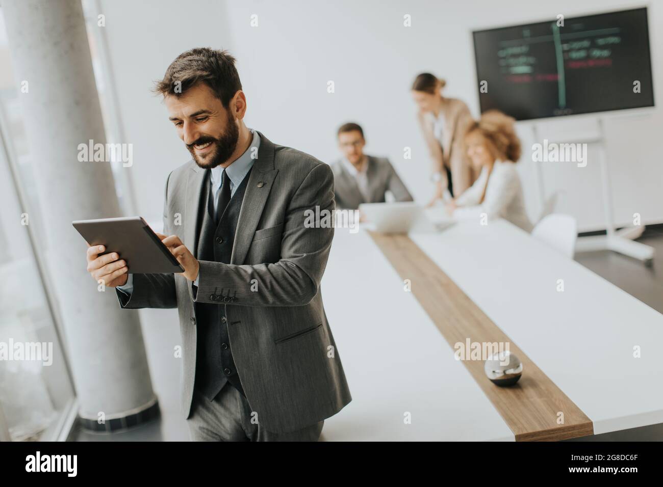 Handsome young modern businessman using digital tablet in the office ...