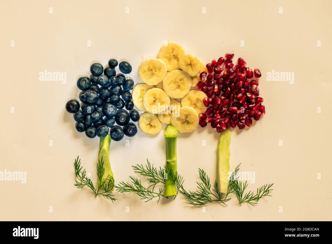 fruit trees made from banana, blueberries, pomegranate apples isolated on yellow backgrounds Stock Photo
