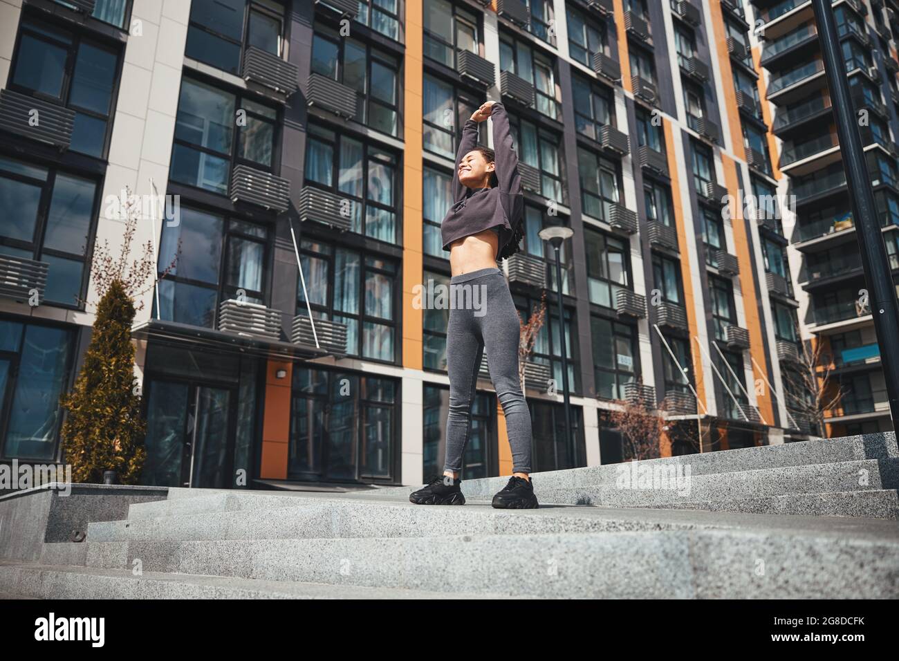 Cute joyous woman performing a stretching exercise Stock Photo