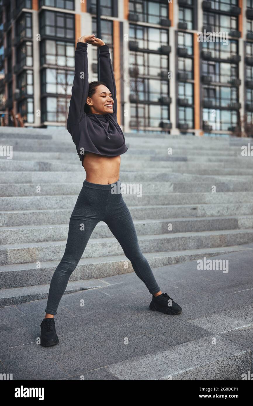 Joyful female athlete doing a stretching exercise Stock Photo