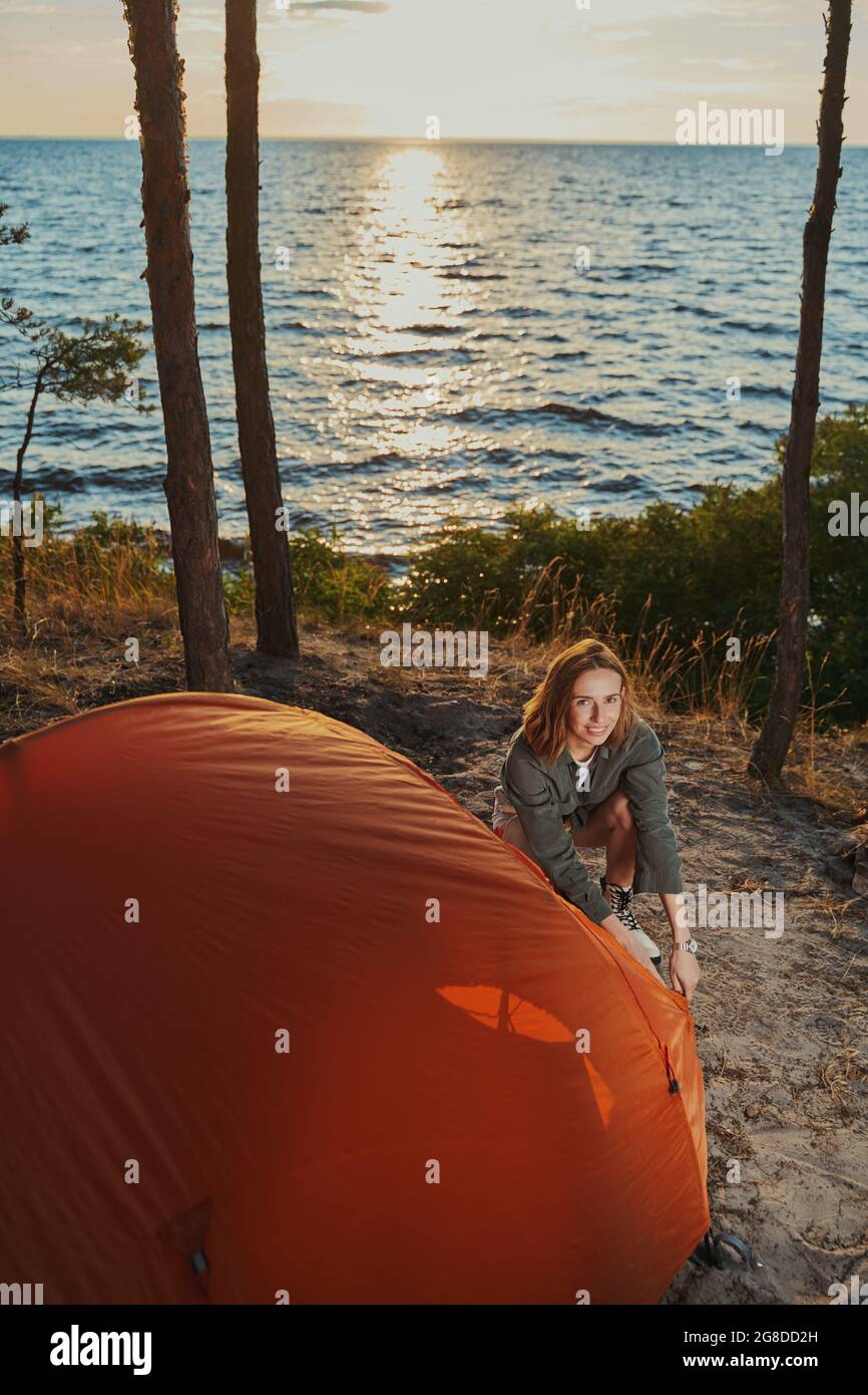 Backpacker is installing tent in the woods Stock Photo