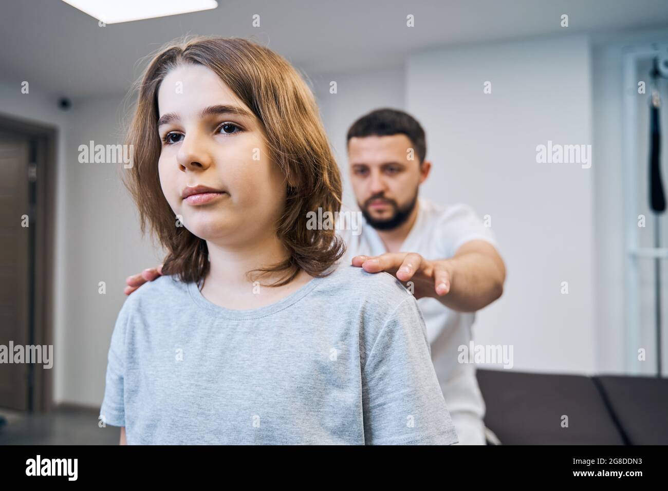 Physiotherapist doctor examines girl neck, spine in medical center