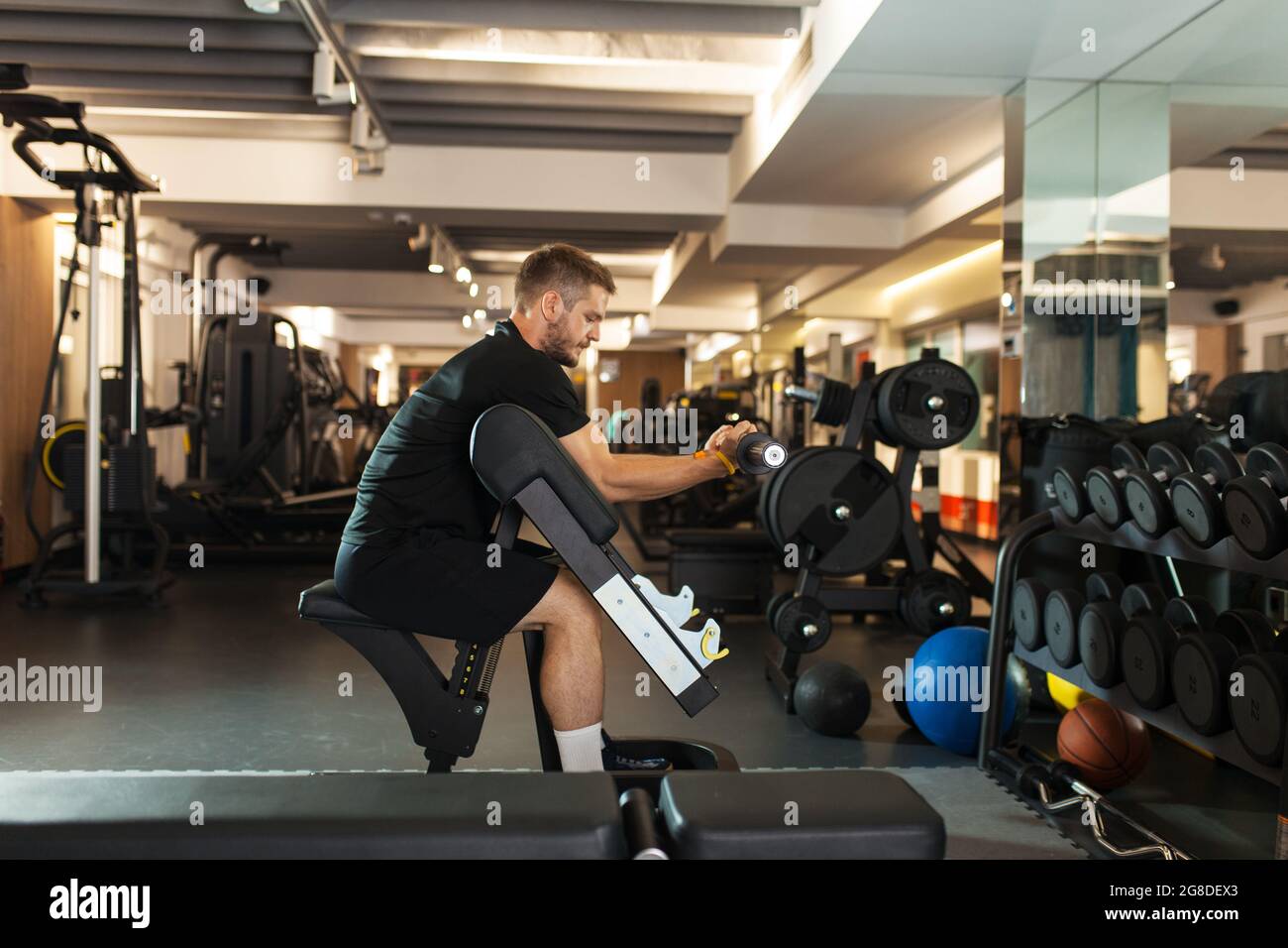 boy lifting barbell pole in a generic out of focus fitness club Stock Photo