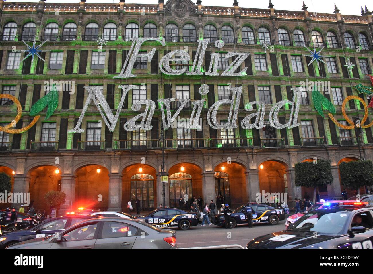 During Christmas, buildings surrounding the zocalo in Mexico City are lit with Christmas colors and greetings. 'Feliz Navidad' means Happy Christmas. Stock Photo