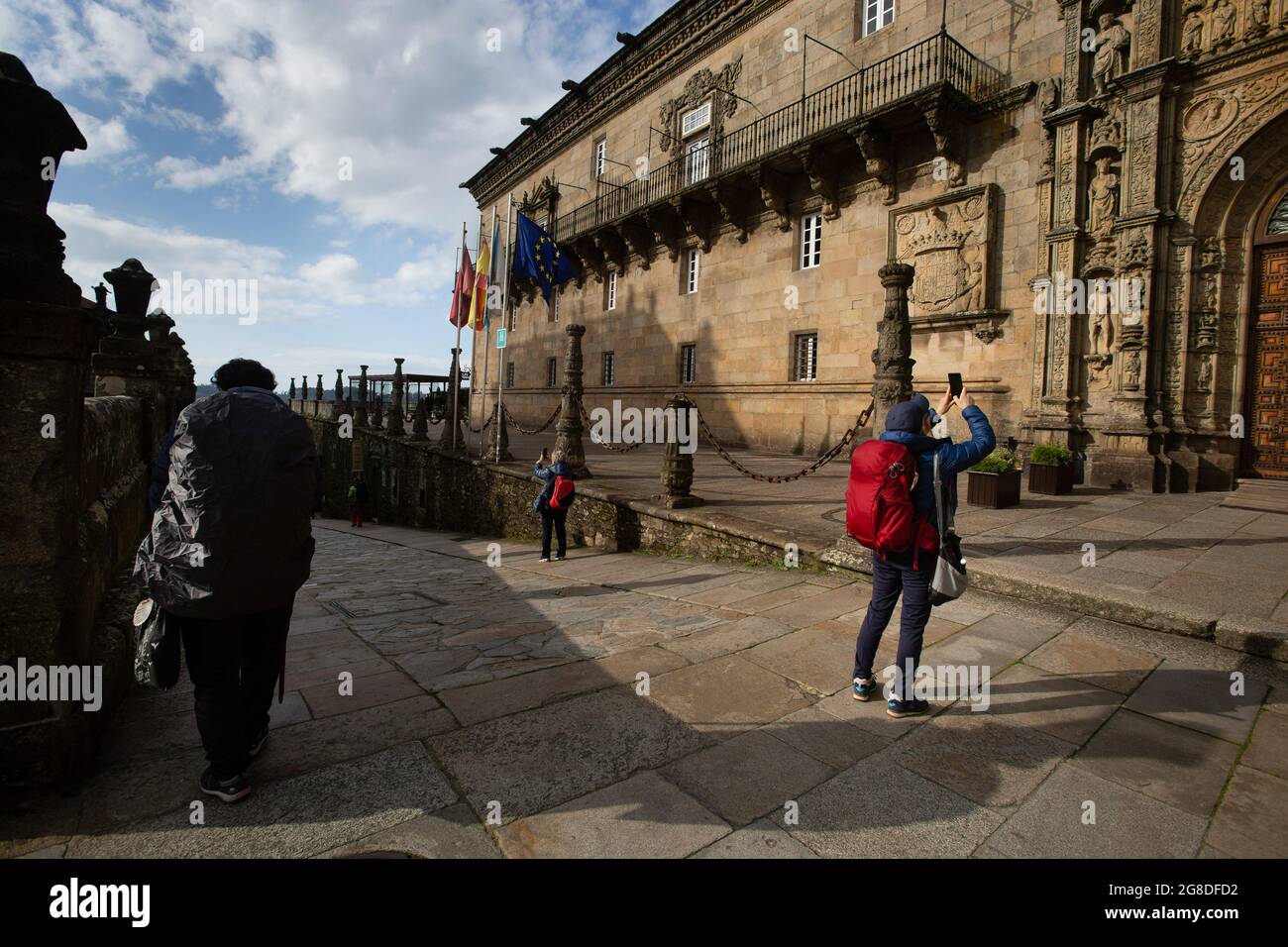 Varios peregrinos hacen fotos del Hostal de los reyes Católicos en Santiago de Compostela. Stock Photo